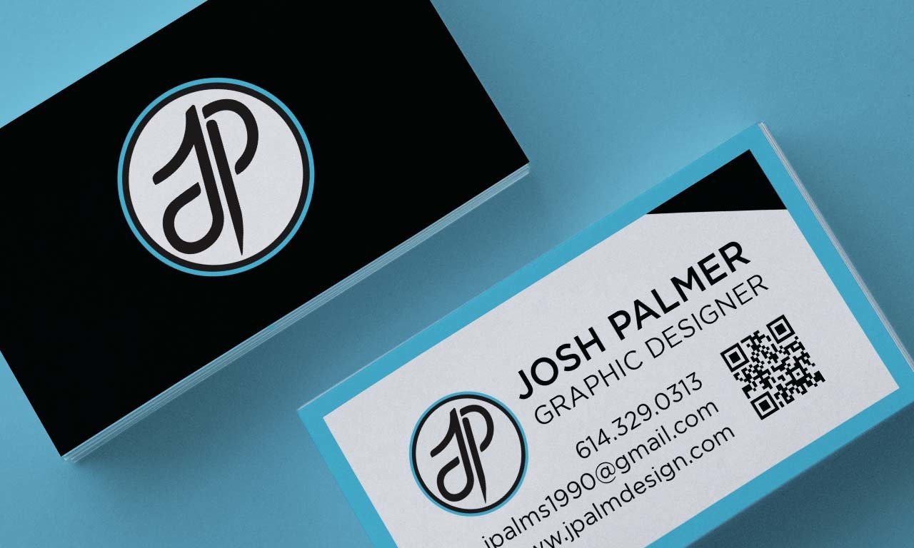 JpalmDesign business cards — a black monogram face and a white contact back with QR code, shown stacked on a blue surface
