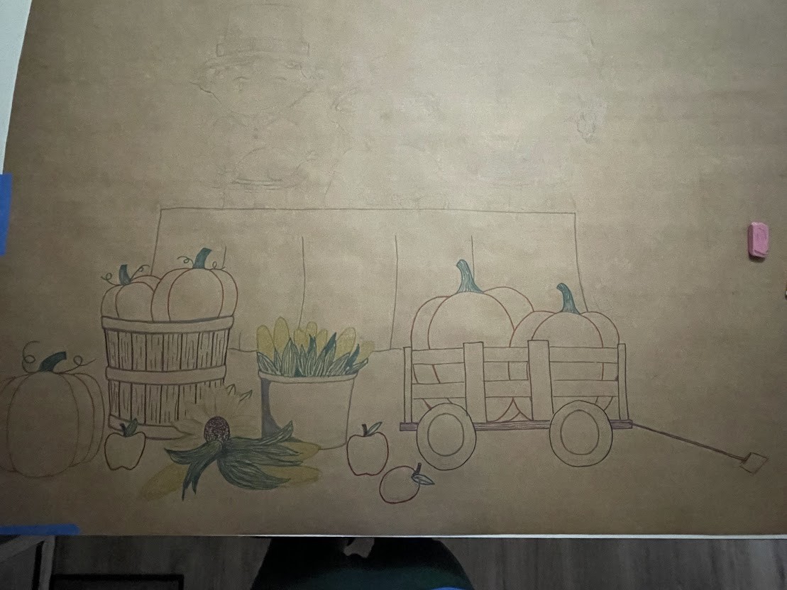 The Thanksgiving banner in progress — line work laid in and the produce partially colored, the figures still uncolored