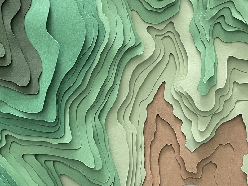 The finished layered-paper topographic shadowbox — stacked green contour bands in relief