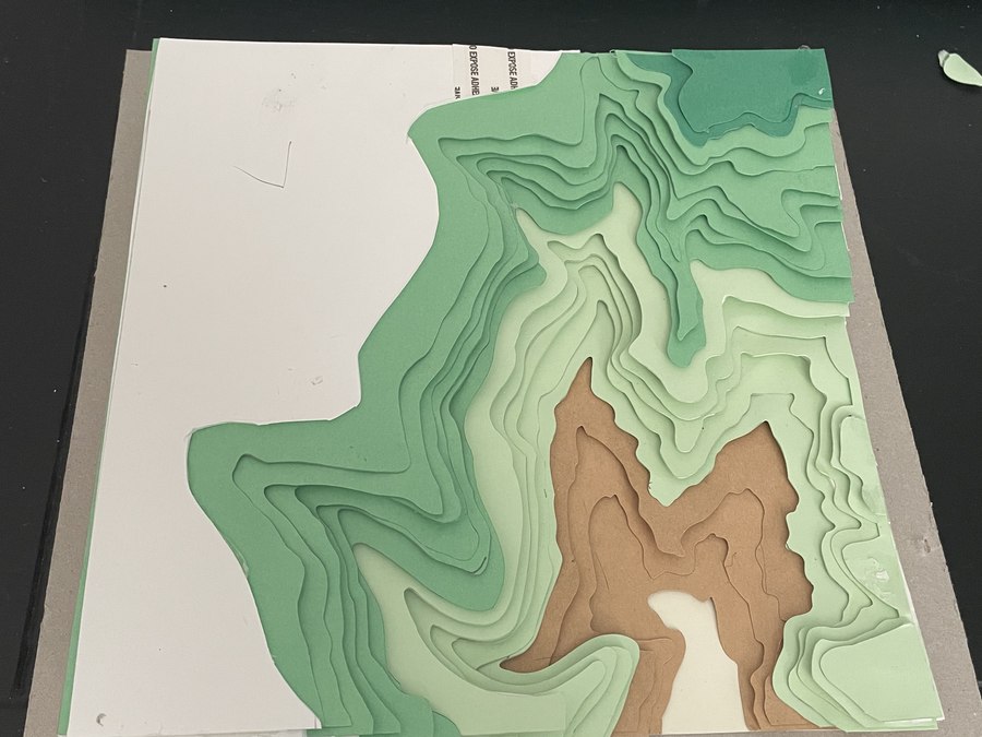 Step 3 — cut paper layers stacking up in the frame beside the cutting machine